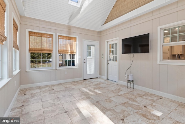 unfurnished sunroom featuring vaulted ceiling with skylight