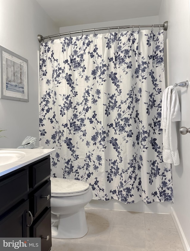 full bath featuring toilet, shower / tub combo, vanity, and tile patterned floors