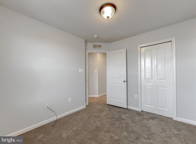 unfurnished bedroom featuring carpet floors, a closet, visible vents, and baseboards