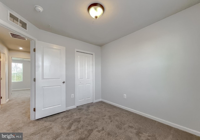 unfurnished bedroom featuring carpet, visible vents, and baseboards