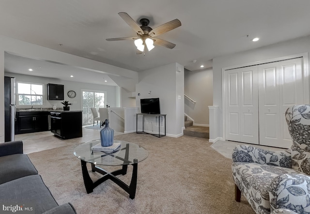 living area with recessed lighting, light carpet, stairway, and baseboards