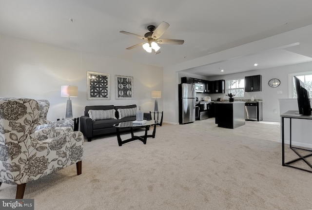 living room featuring a ceiling fan, light carpet, and baseboards