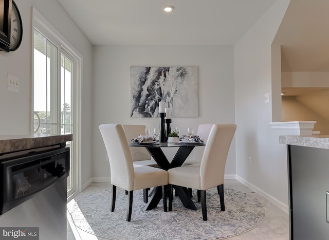 dining room with a glass covered fireplace and baseboards