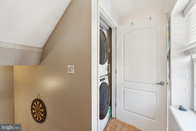 washroom featuring light hardwood / wood-style floors and stacked washer and clothes dryer