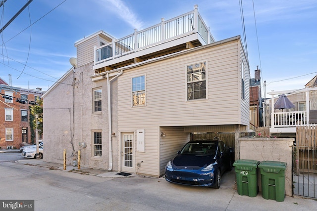 rear view of house featuring a balcony and a carport