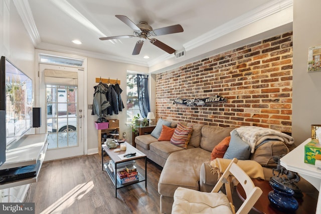 living room with ceiling fan, crown molding, dark hardwood / wood-style flooring, and brick wall