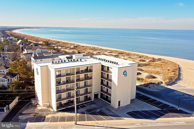 drone / aerial view with a water view and a beach view