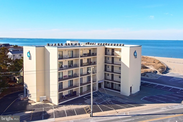 view of property with a view of the beach and a water view