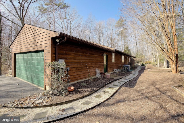 view of home's exterior with central AC, a garage, and an outdoor structure