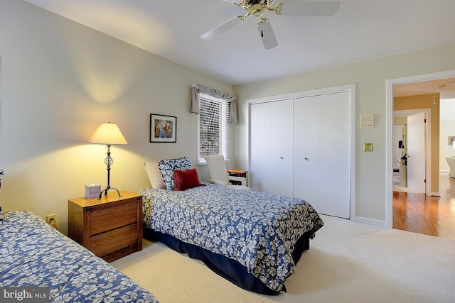 bedroom featuring light carpet, ceiling fan, and a closet