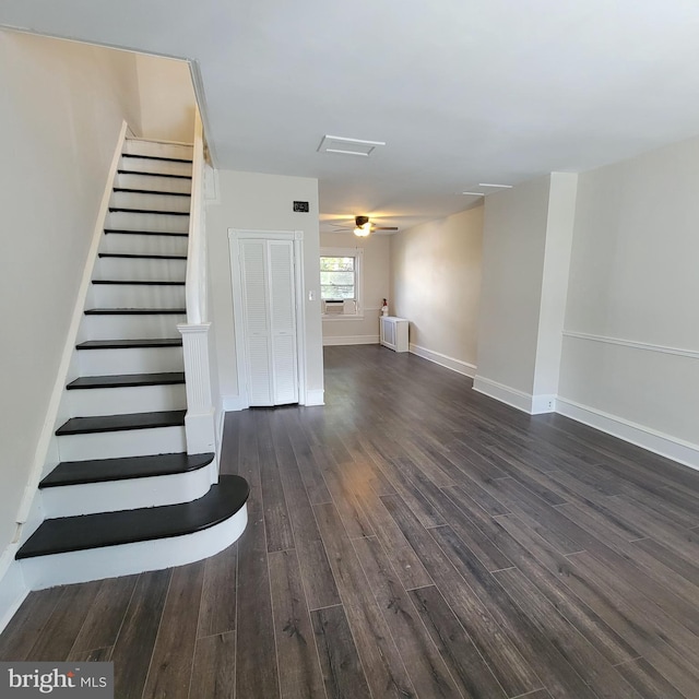 interior space with dark wood-type flooring, baseboards, and stairs