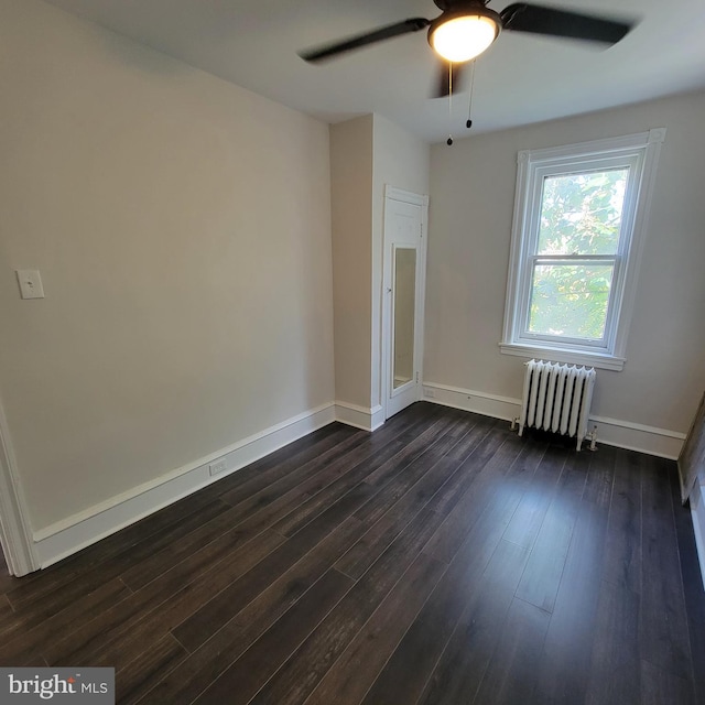 unfurnished room with radiator, baseboards, ceiling fan, and dark wood-style flooring