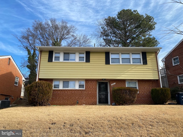 view of front of home with a front lawn and central air condition unit