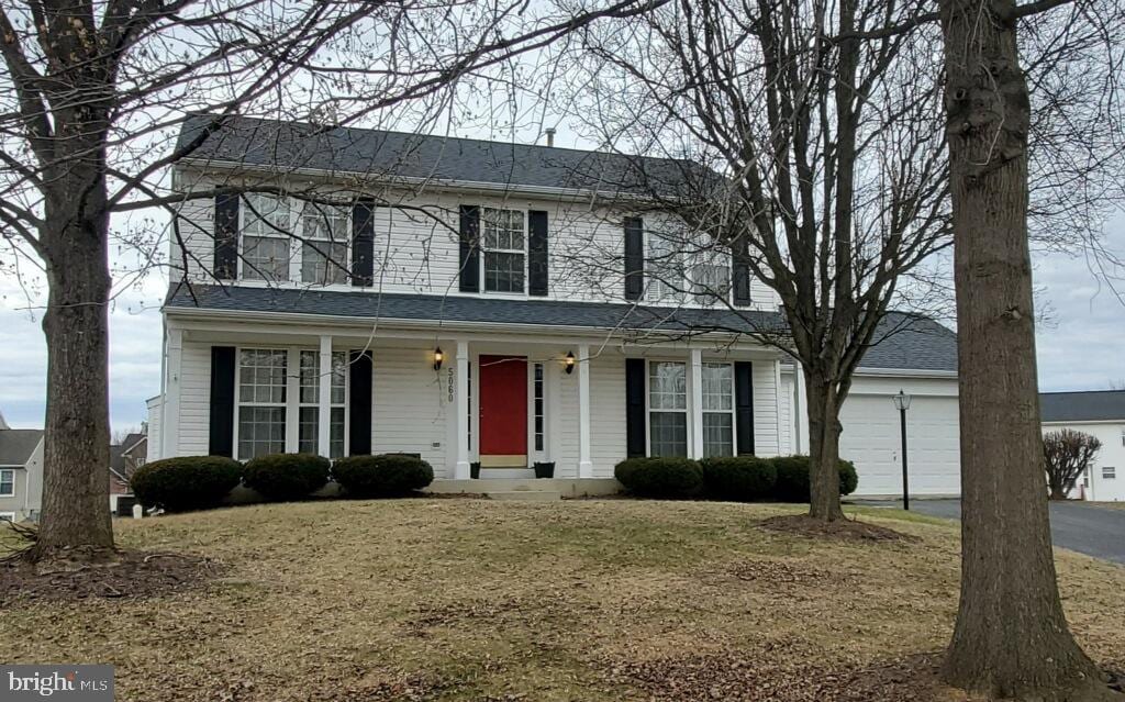 view of front facade featuring a garage, covered porch, and aphalt driveway