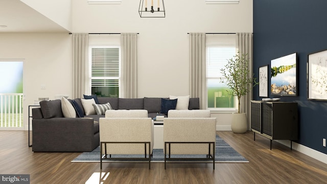 living room with a towering ceiling and dark hardwood / wood-style flooring