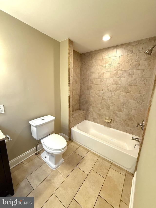 full bathroom featuring tile patterned flooring, vanity, tiled shower / bath combo, and toilet