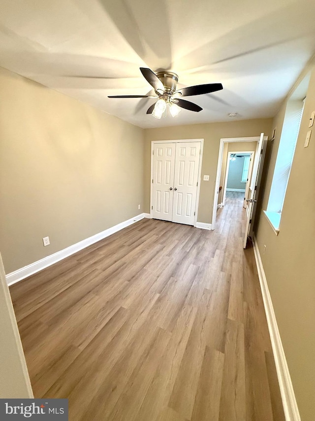 unfurnished bedroom with ceiling fan, light hardwood / wood-style floors, and a closet