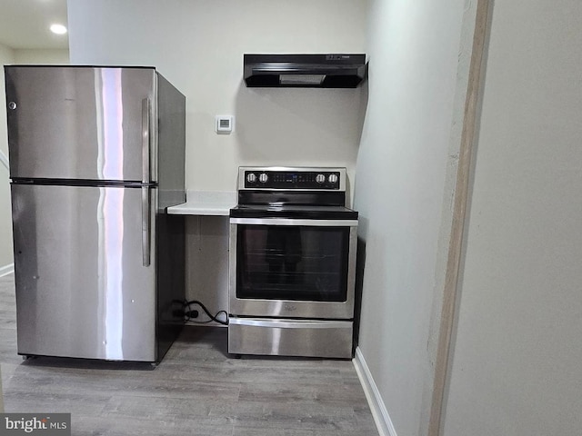 kitchen featuring ventilation hood, stainless steel appliances, and light hardwood / wood-style floors