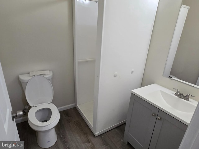 bathroom featuring vanity, toilet, hardwood / wood-style floors, and walk in shower