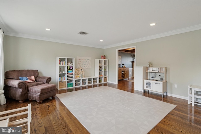 sitting room with crown molding and dark wood-type flooring