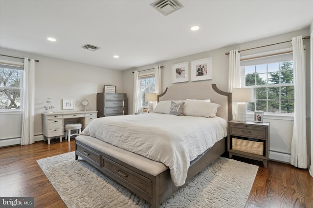 bedroom with dark wood-type flooring and baseboard heating