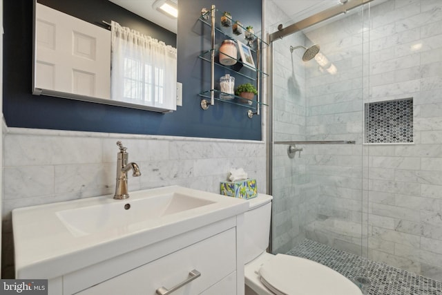 bathroom with walk in shower, vanity, toilet, and tile walls