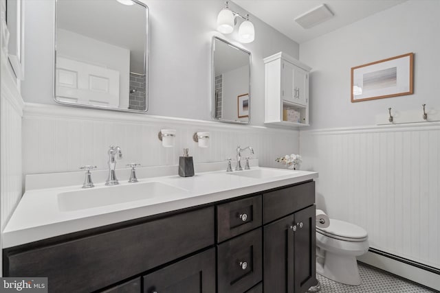 bathroom featuring a baseboard radiator, vanity, toilet, and tile patterned flooring