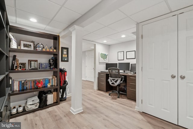 office with a drop ceiling and light wood-type flooring