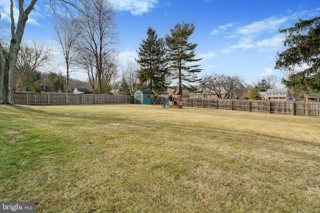 view of yard with a storage shed and a playground