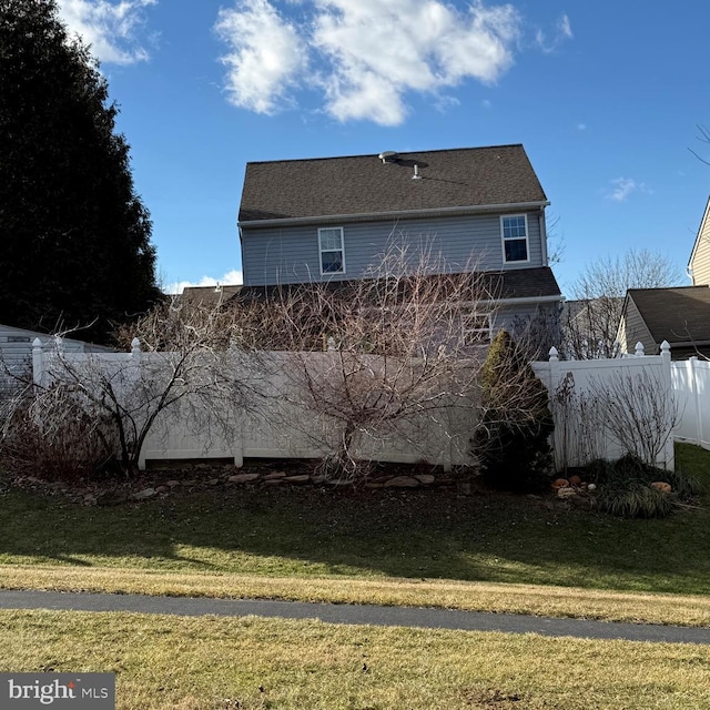 view of home's exterior featuring a lawn and fence