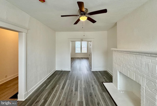 unfurnished living room featuring ceiling fan and dark hardwood / wood-style flooring