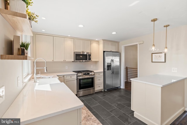 kitchen with decorative light fixtures, sink, kitchen peninsula, stainless steel appliances, and cream cabinets