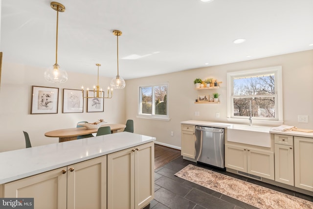 kitchen with hanging light fixtures, sink, stainless steel dishwasher, and cream cabinetry