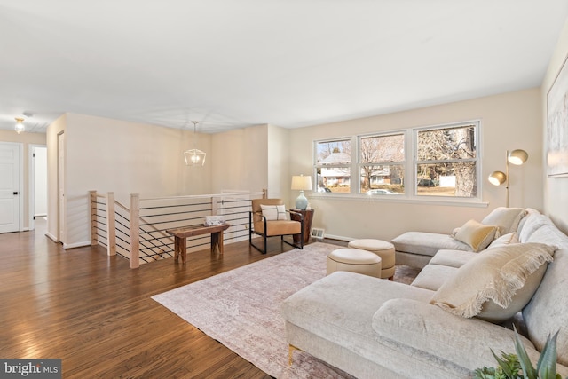 living room with an inviting chandelier and dark hardwood / wood-style floors