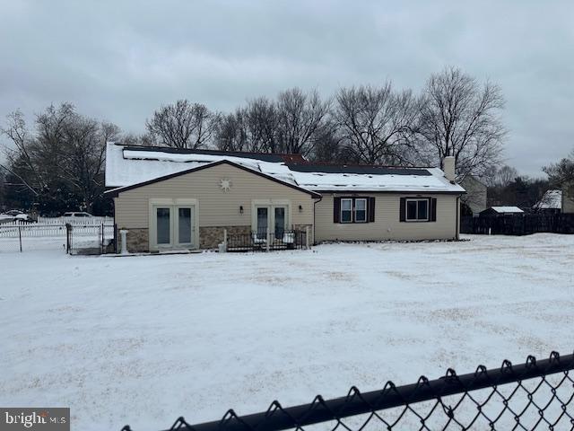 snow covered back of property featuring french doors