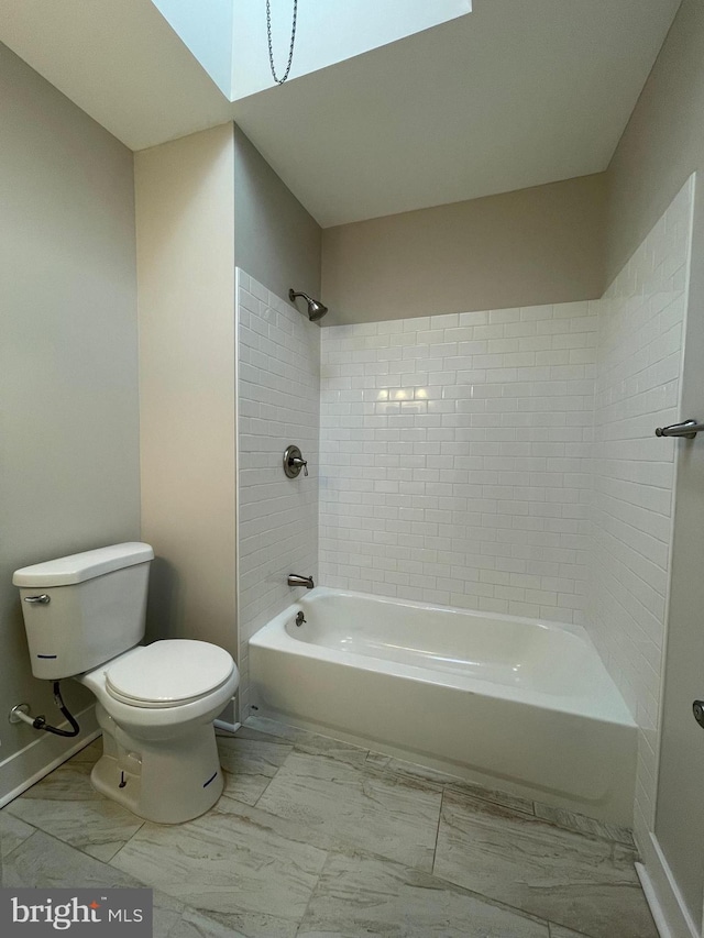 bathroom featuring tiled shower / bath and toilet