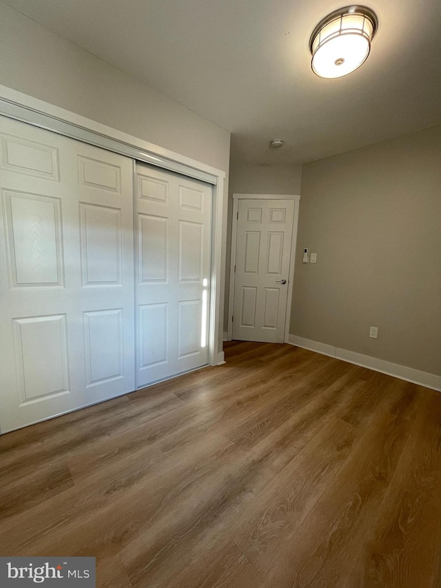 unfurnished bedroom featuring hardwood / wood-style flooring and a closet