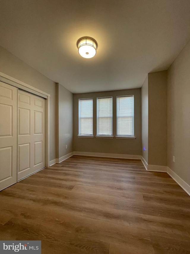 unfurnished bedroom with wood-type flooring and a closet