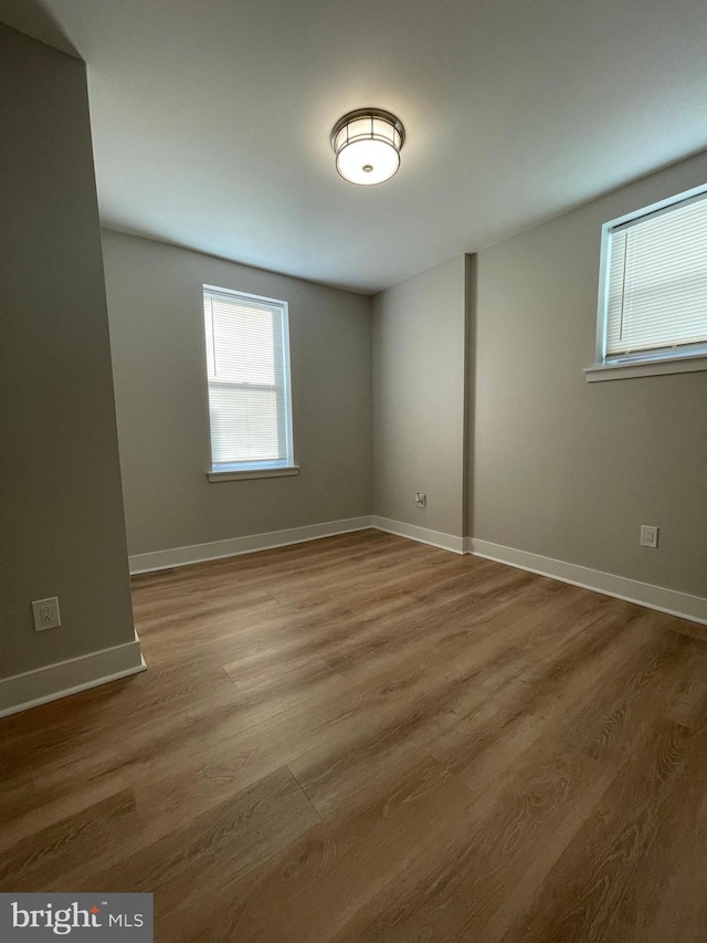 unfurnished room with hardwood / wood-style flooring