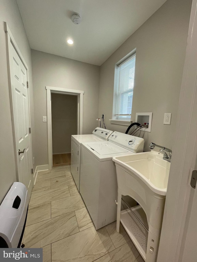 washroom with separate washer and dryer and sink