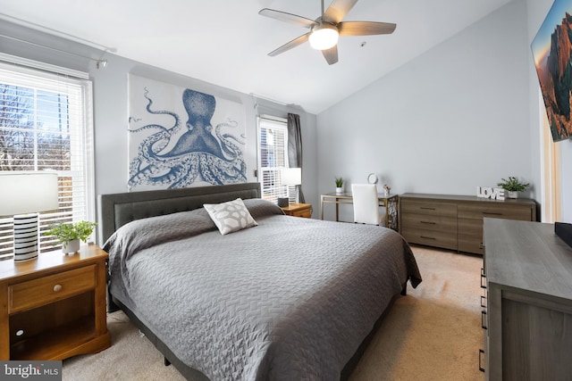 bedroom with a ceiling fan, lofted ceiling, multiple windows, and light carpet