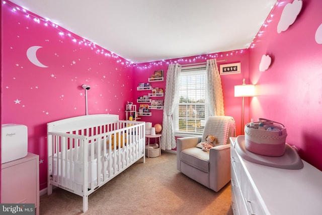 bedroom with a nursery area and carpet floors