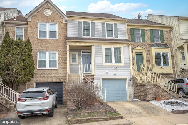 view of property featuring a garage, concrete driveway, and stairway