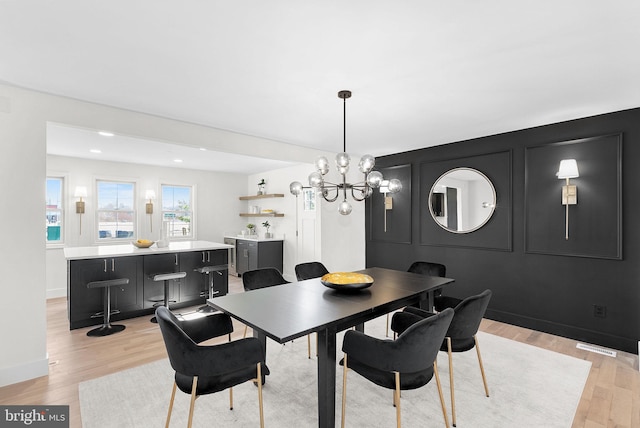 dining room with a notable chandelier and light wood-type flooring