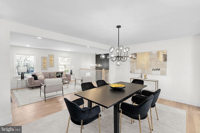 dining area with a notable chandelier and light hardwood / wood-style flooring