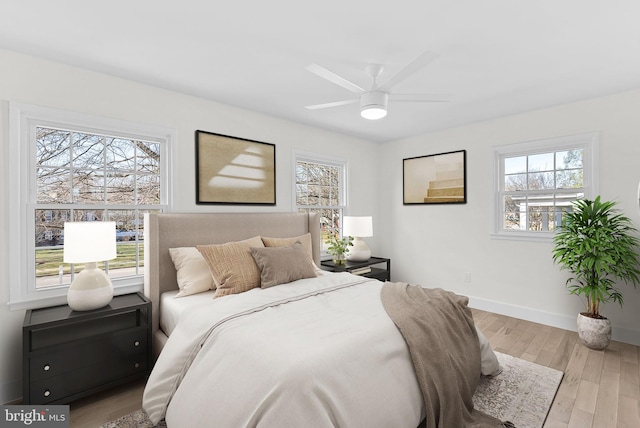 bedroom featuring multiple windows and light hardwood / wood-style flooring