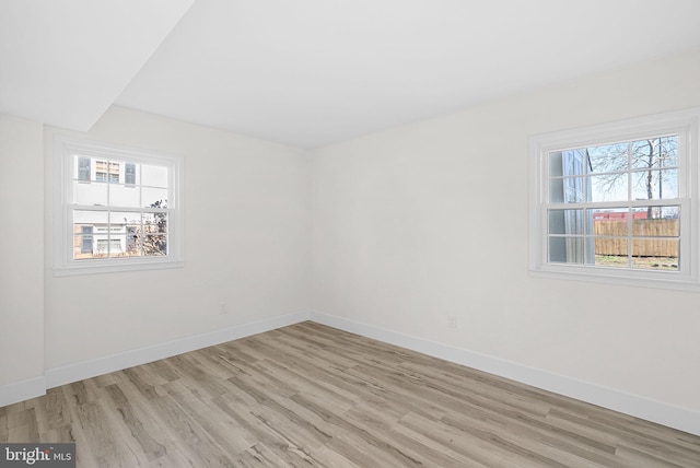 spare room featuring light hardwood / wood-style floors and a wealth of natural light