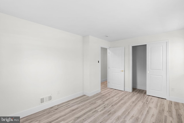 unfurnished bedroom featuring a closet and light wood-type flooring