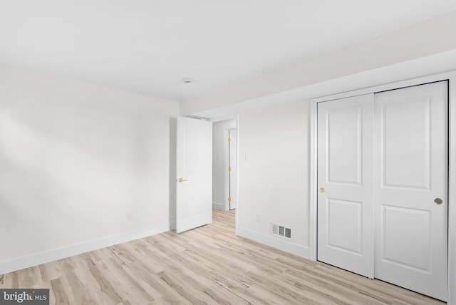 unfurnished bedroom with a closet and light hardwood / wood-style flooring