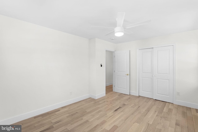 unfurnished bedroom featuring ceiling fan, light hardwood / wood-style floors, and a closet